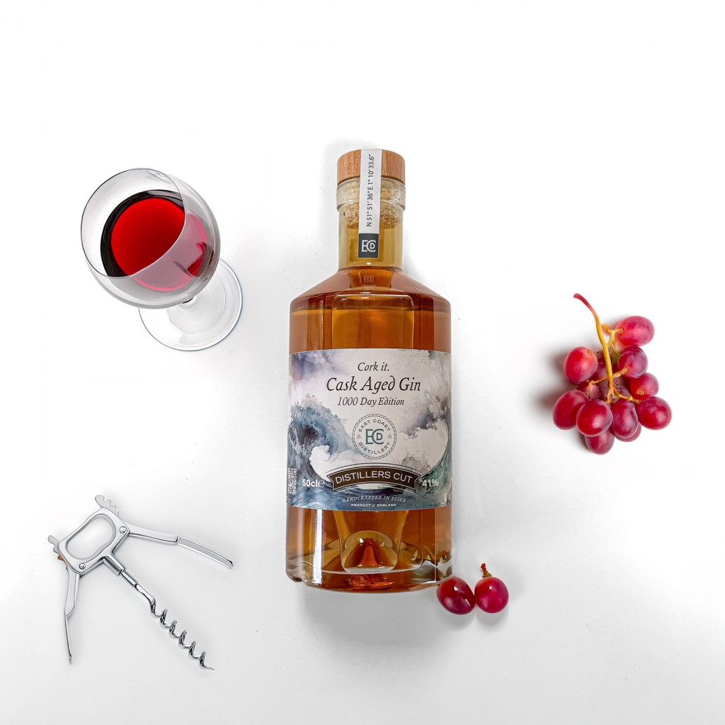 cork-it-product-2 Bottle of gin on a white background with a corkscrew and glass of red wine from above